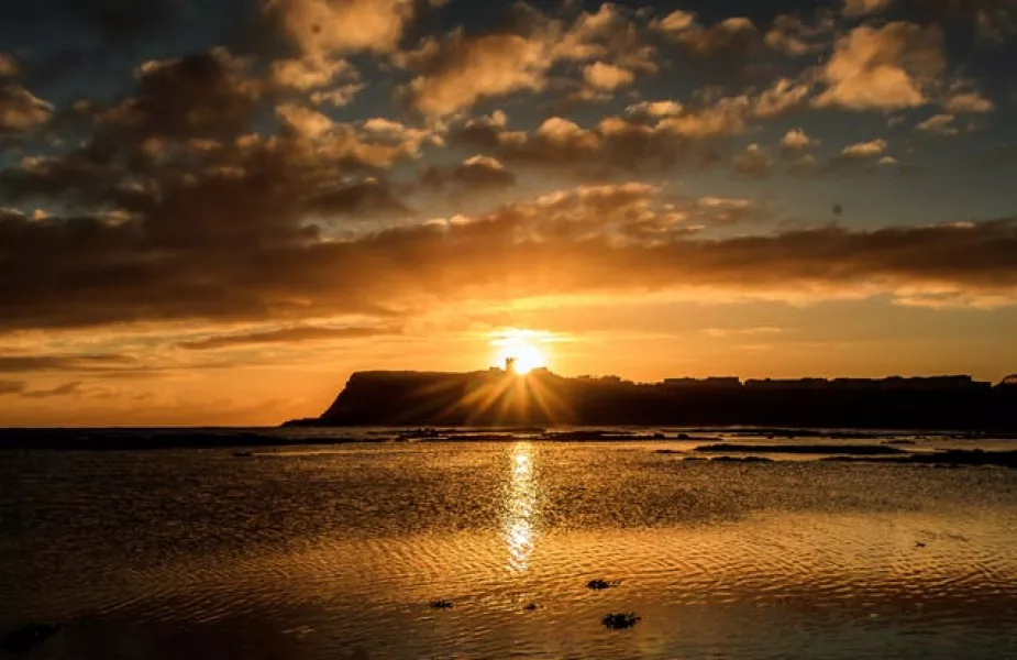 The sun rises behind Scarborough Castle in Yorkshire (Danny Lawson/PA)
