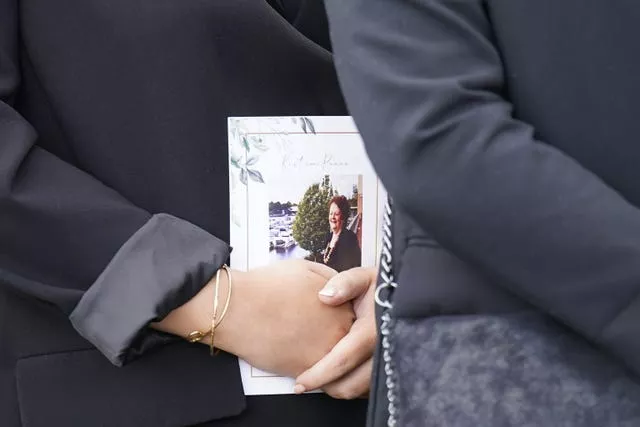 A mourner holds an Order of Service 