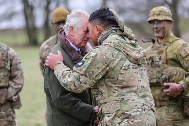 The King receives the hongi - the traditional Maori greeting - from a New Zealander who is part of the Ukrainian contingent during a visit to a training site for Ukrainian military recruits in Wiltshire