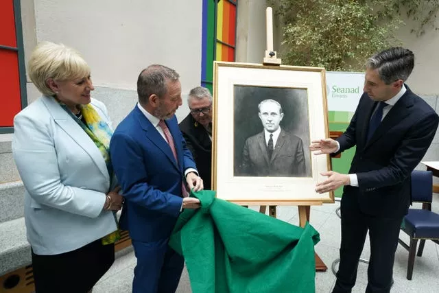 Taoiseach Simon Harris with Rural Minister Heather Humphreys and Seanad Cathaoirleach Jerry Buttimer look at a portrait of Billy Fox