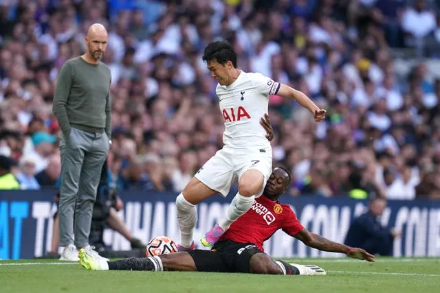 Tottenham’s Son Heung-min and Manchester United’s Aaron Wan-Bissaka, right, battle for the ball watched by United manager Erik ten Hag, left