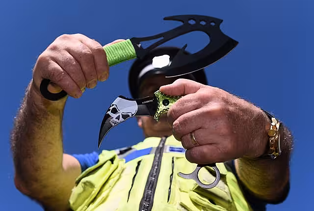 A police officer holds two examples of zombie knives