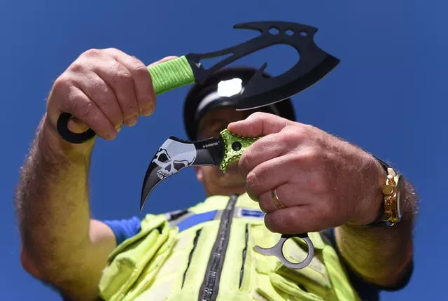 A police officer holds two examples of zombie knives 