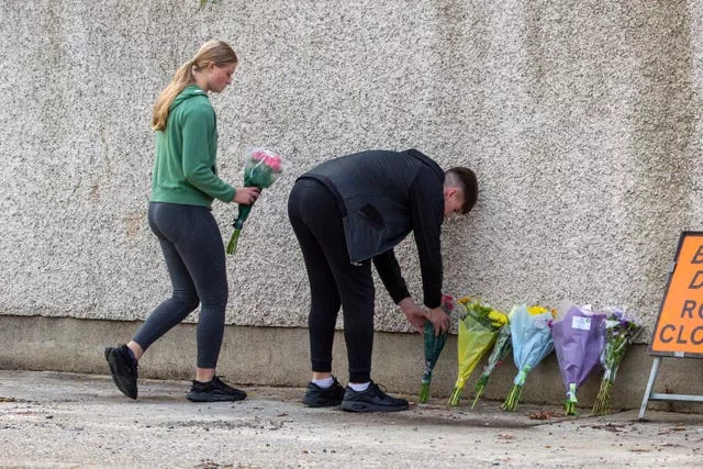 Friends leave flowers near the scene of the crash