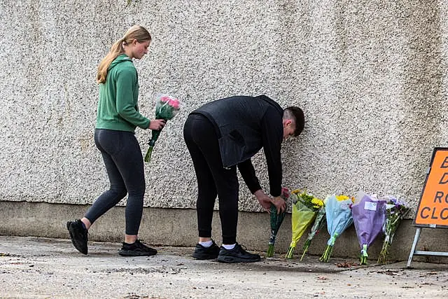 Friends leave flowers near the scene of the crash