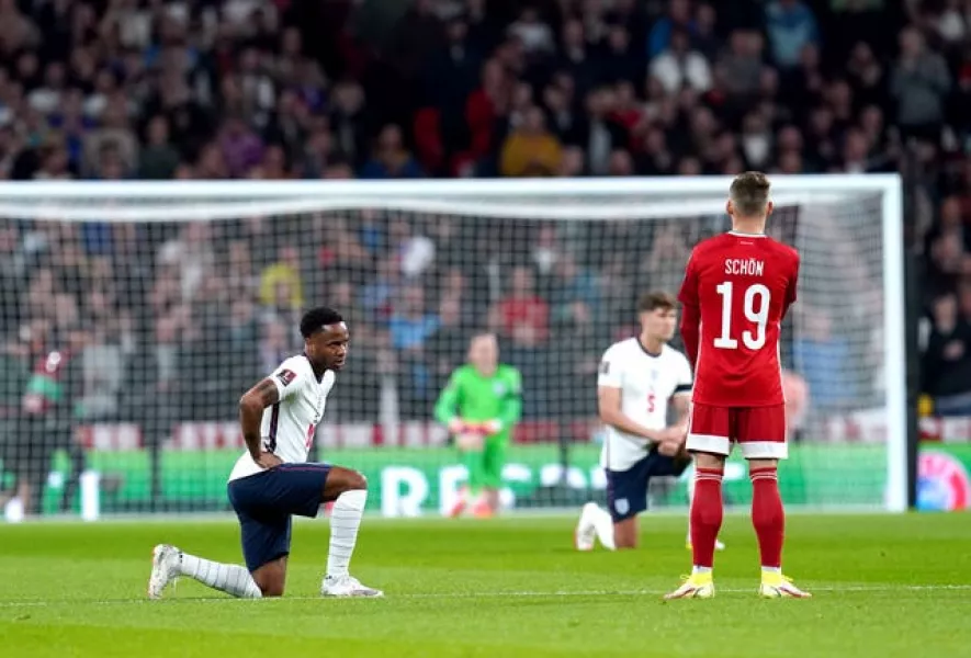 England's Raheem Sterling takes a knee as Hungary's Szabolcs Schon remains standing