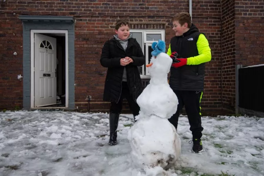 Teenage brothers build snowman