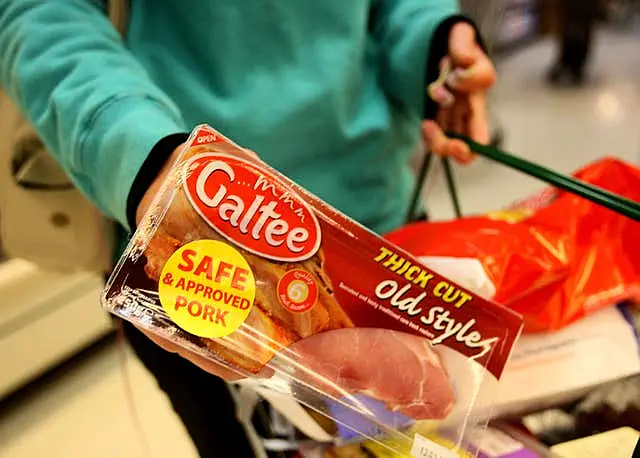 A customer holds a pack of bacon (Julien Behal/PA)