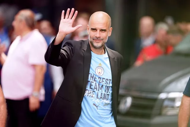 Pep Guardiola waves as he leaves the hotel