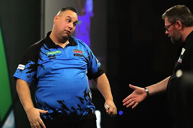 Jermaine Wattimena (left) celebrates victory against James Wade (right) at the World Darts Championship