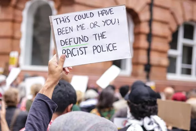 A protester holds up a placard during a Stand Up To Racism demonstration in Manchester