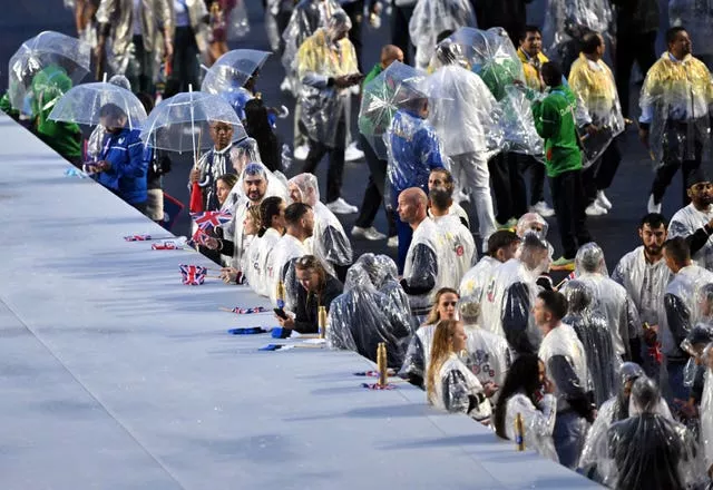 Athletes from the Great Britain team shelter from the rain at the Trocadero