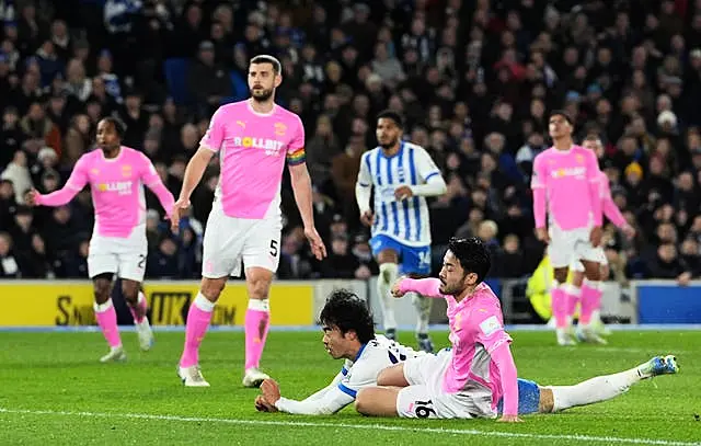 Kaoru Mitoma, centre, dives ahead of Yukinari Sugawara to head Brighton in front against Southampton