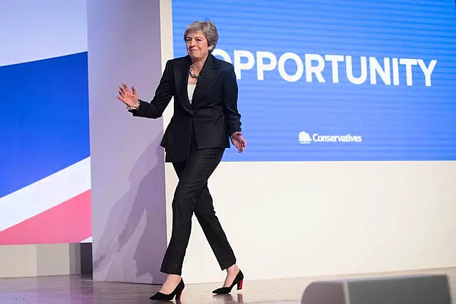 Theresa May dancing in front of Conservative signage