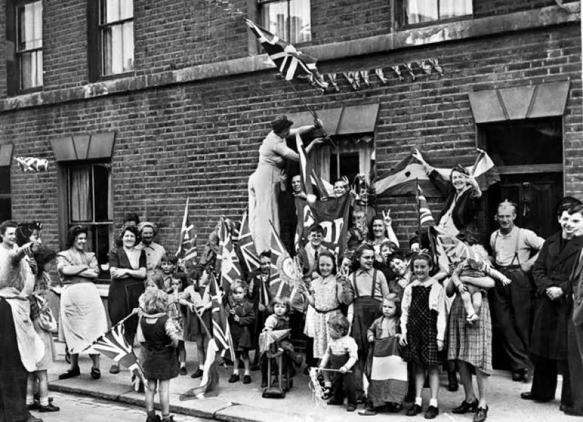 British men, women and children celebrating Victory in Europe Day in the street in 1945