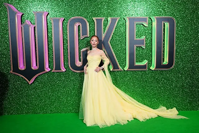 Ariana Grande in a lime green dress before the Wicked movie marquee