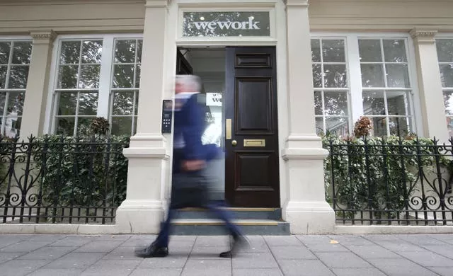 Man blurred as he walks past a WeWork office