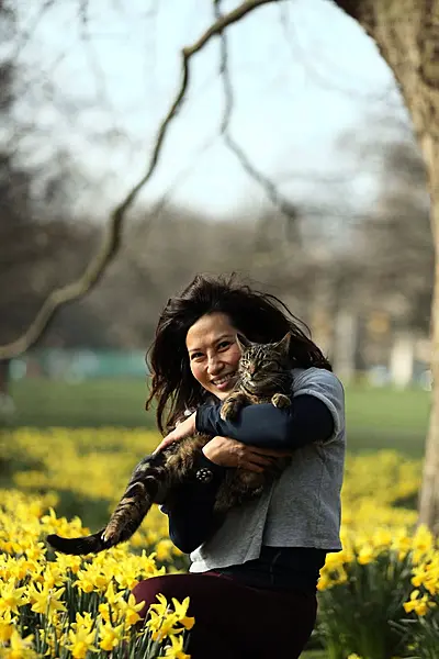 Serena with her cat, Chummy, among the daffodils in London