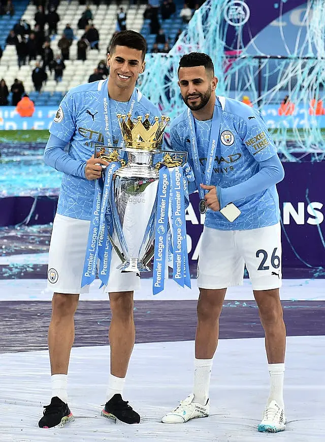 Joao Cancelo and Riyad Mahrez celebrate winning the Premier League