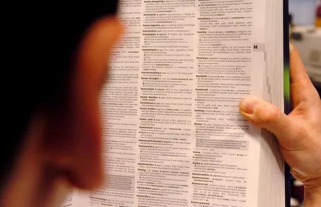 A man reads a copy of the Oxford Dictionary of English