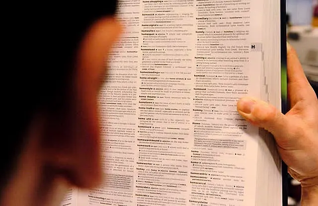 A man reads a copy of the Oxford Dictionary of English