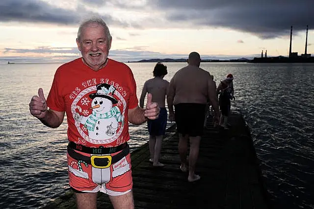 An elderly man in a Christmas outfit