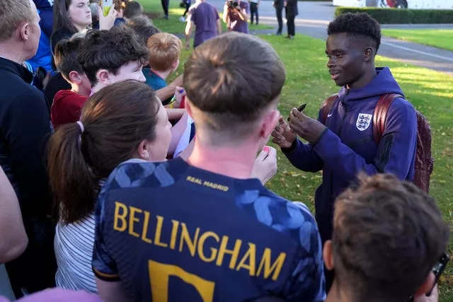 England’s Bukayo Saka, right, signs autographs for fans in Ireland