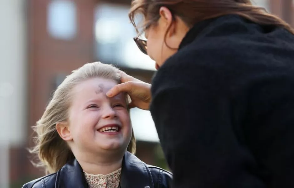 Annalee Corcoran, six, receives ashes from her aunty Maria Corcoran outside their home in Meakstown, Dublin