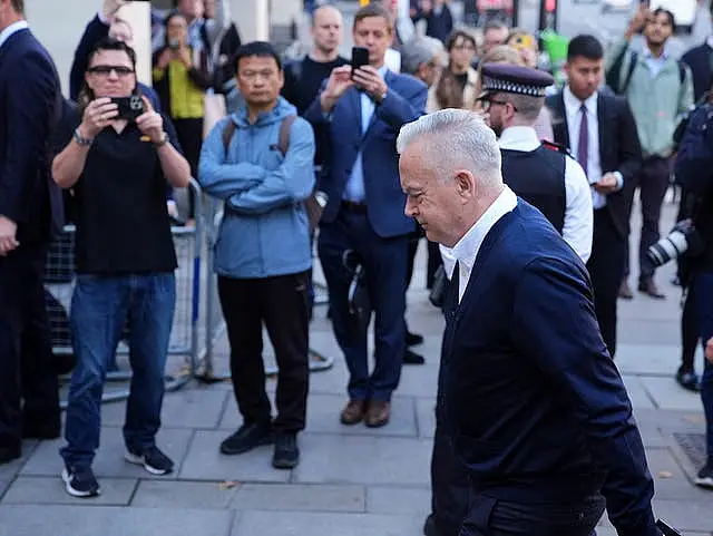 Huw Edwards with photographers in the background