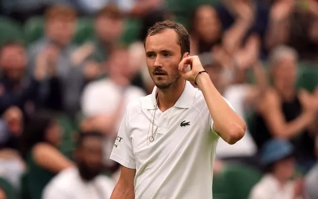 Daniil Medvedev points to his ear in celebration 