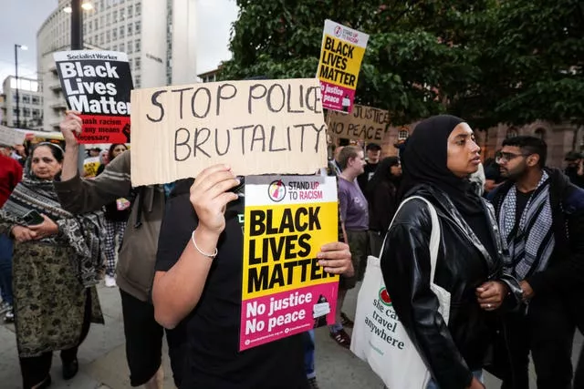 Protesters holding up signs alleging police brutality and calling for it to be stopped