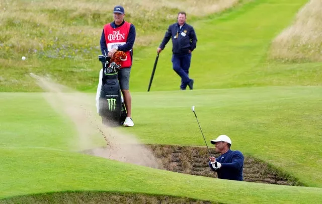 Tiger Woods splashes out of a bunker