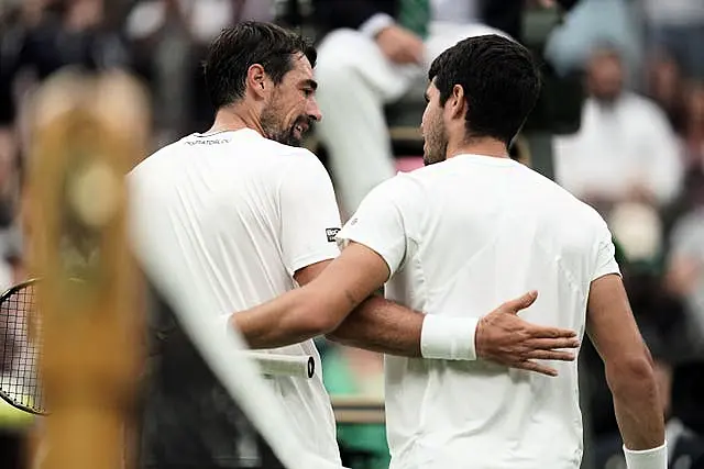 Carlos Alcaraz and Jeremy Chardy (left) embrace at the net after their match 