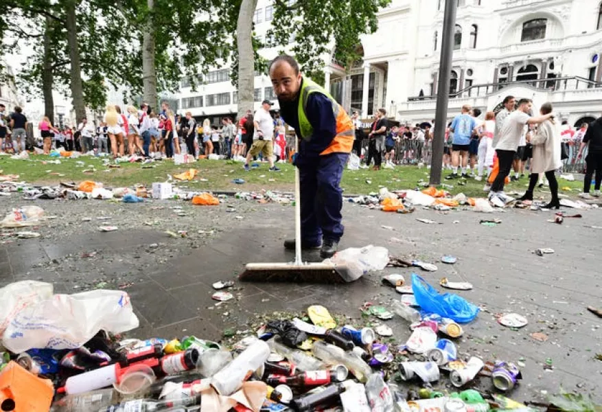 A worker clears rubbish left by fans at Leicester Square, London before the UEFA Euro 2020 Final between Italy and England