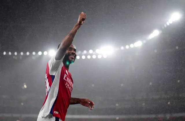 Raheem Sterling raises his right hand to celebrate scoring for Arsenal against Bolton