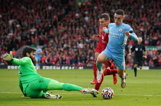 Liverpool goalkeeper Alisson saves from Manchester City’s Phil Foden