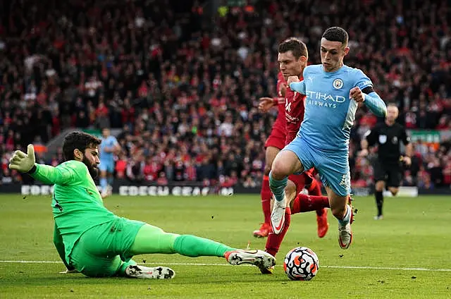 Liverpool goalkeeper Alisson saves from Manchester City’s Phil Foden