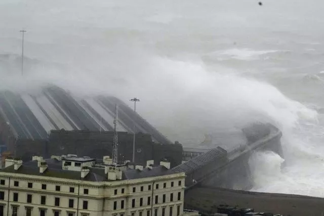 Waves crash over the harbour wall in Folkestone