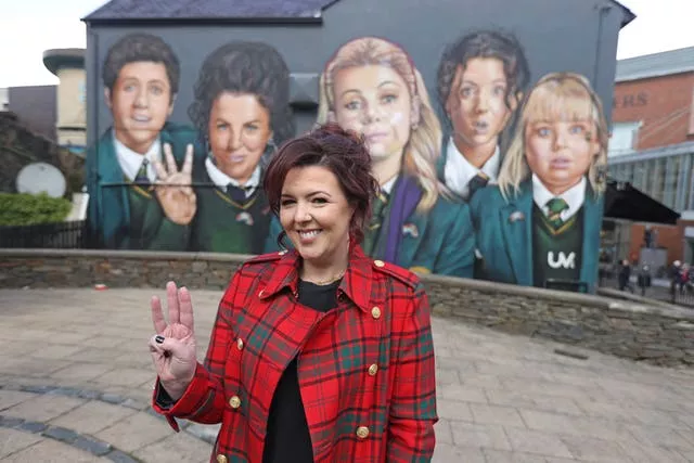 Writer Lisa McGee in front of the Derry Girls mural