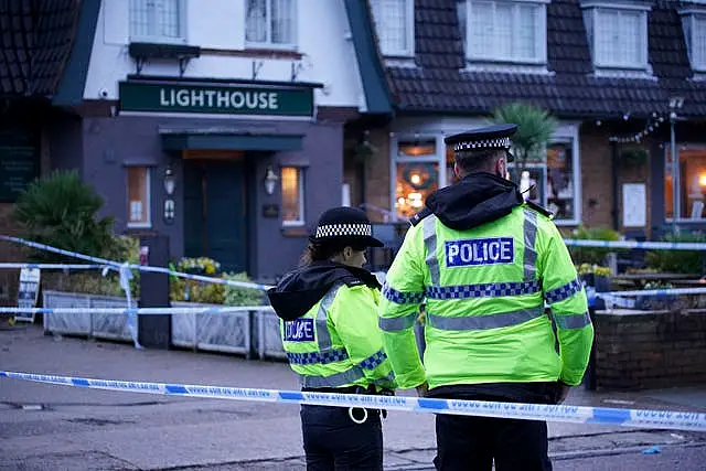 Police officers patrol the cordon outside the pub Wallasey Village (Peter Byrne/PA)