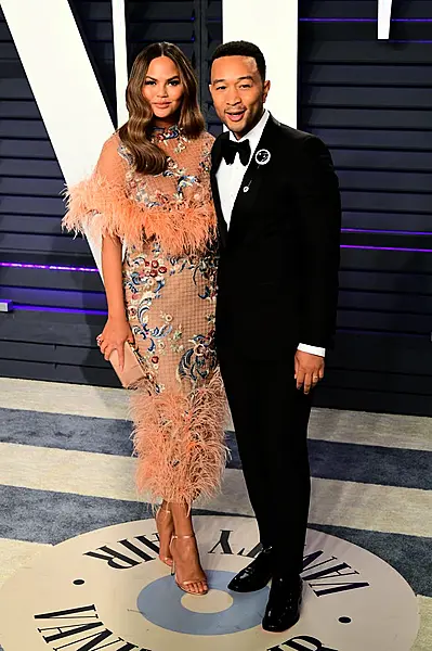 Chrissy Teigen and John Legend posing for pictures.