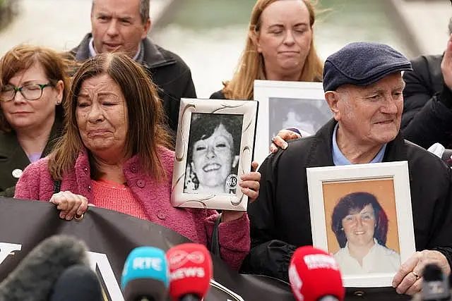 Survivors, family members and supporters hold pictures of those they lost 