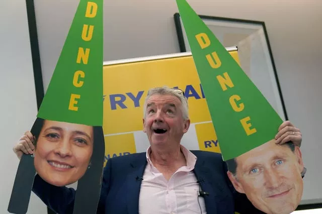 Ryanair chief executive Michael O’Leary holding up masks of Green Party politicians Eamon Ryan and Catherine Martin