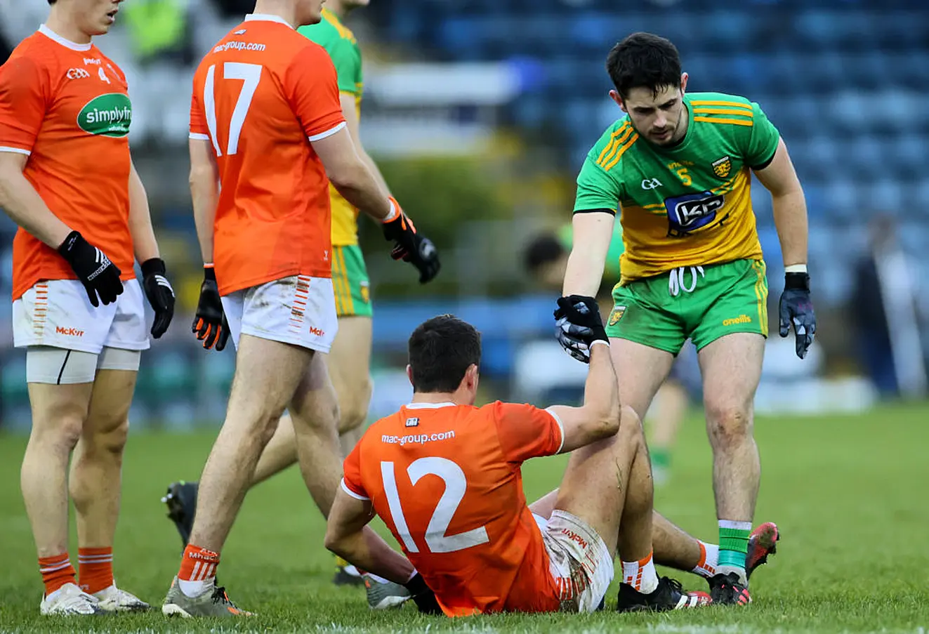 Donegal's Ryan Mchugh Lends A Hand To Armagh's Stefan Campbell. Photo: James Crombie/Inpho