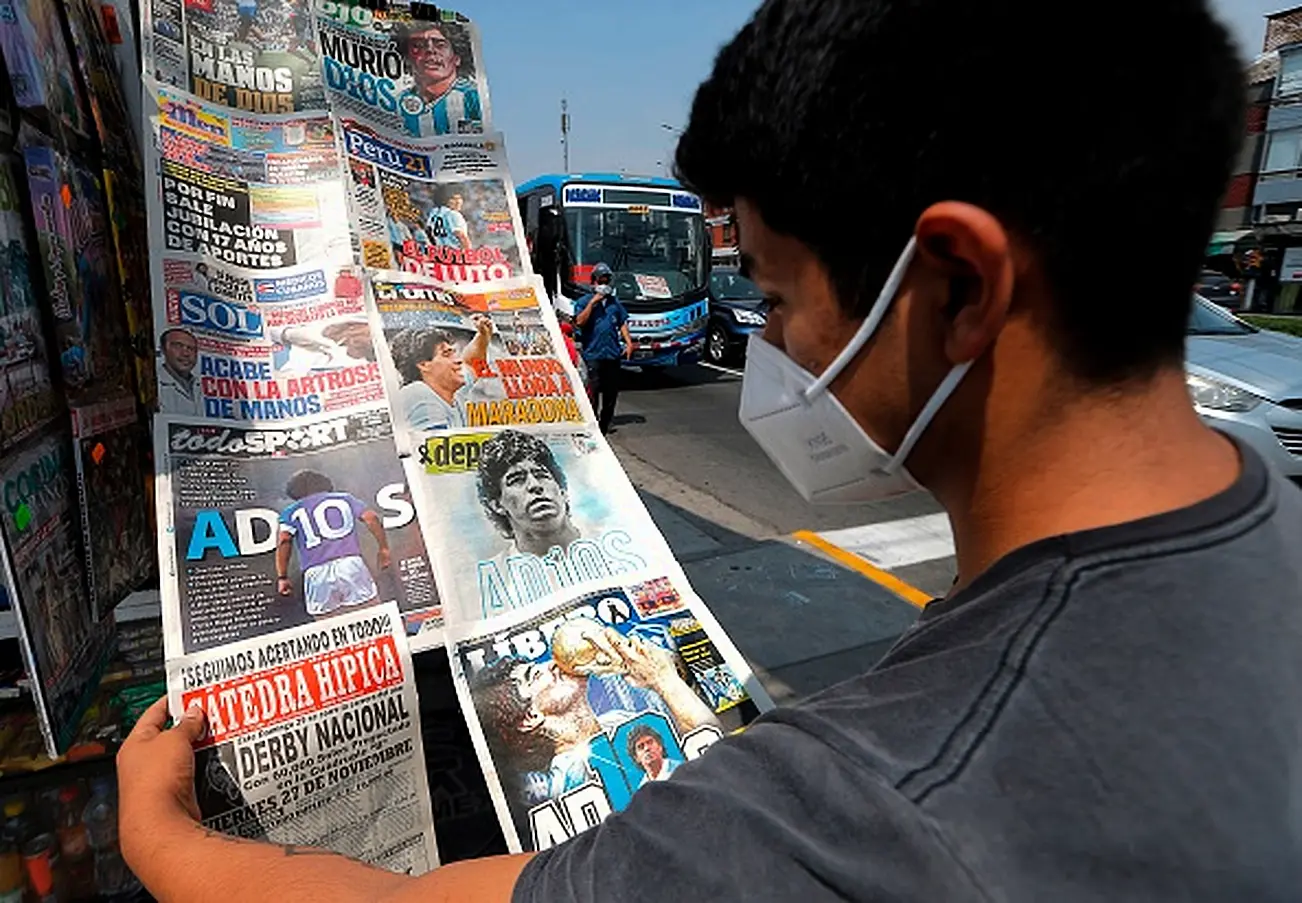 A Youngster Looks At Front Pages Of Newspapers Displayed In A Stand With The News Of Maradona's Death. Photo: Luka Gonzalez/Afp Via Getty Images