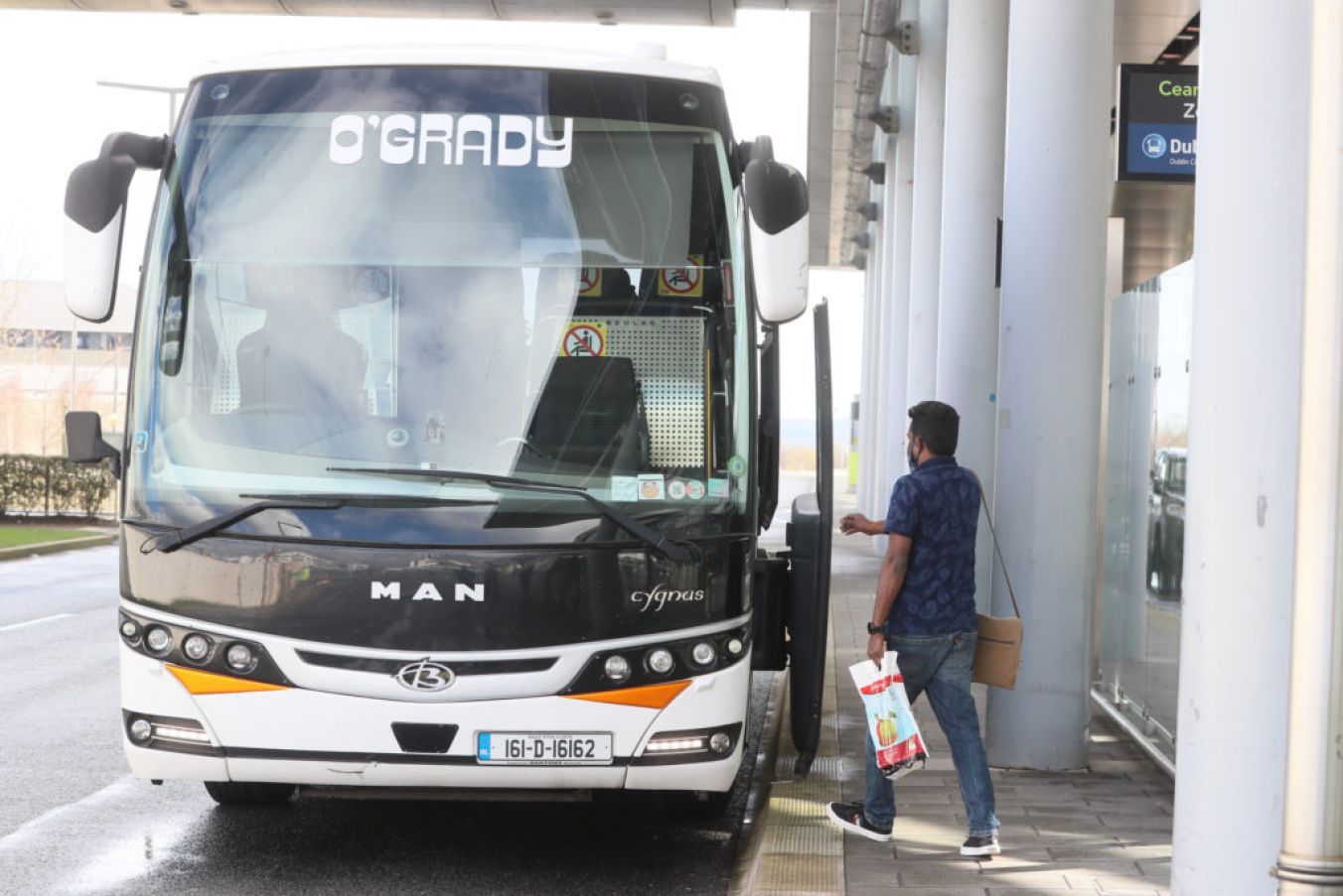 A Passenger Boards A Bus After Arriving From One Of 33 High Risk Countries. Photo: Pa Images.