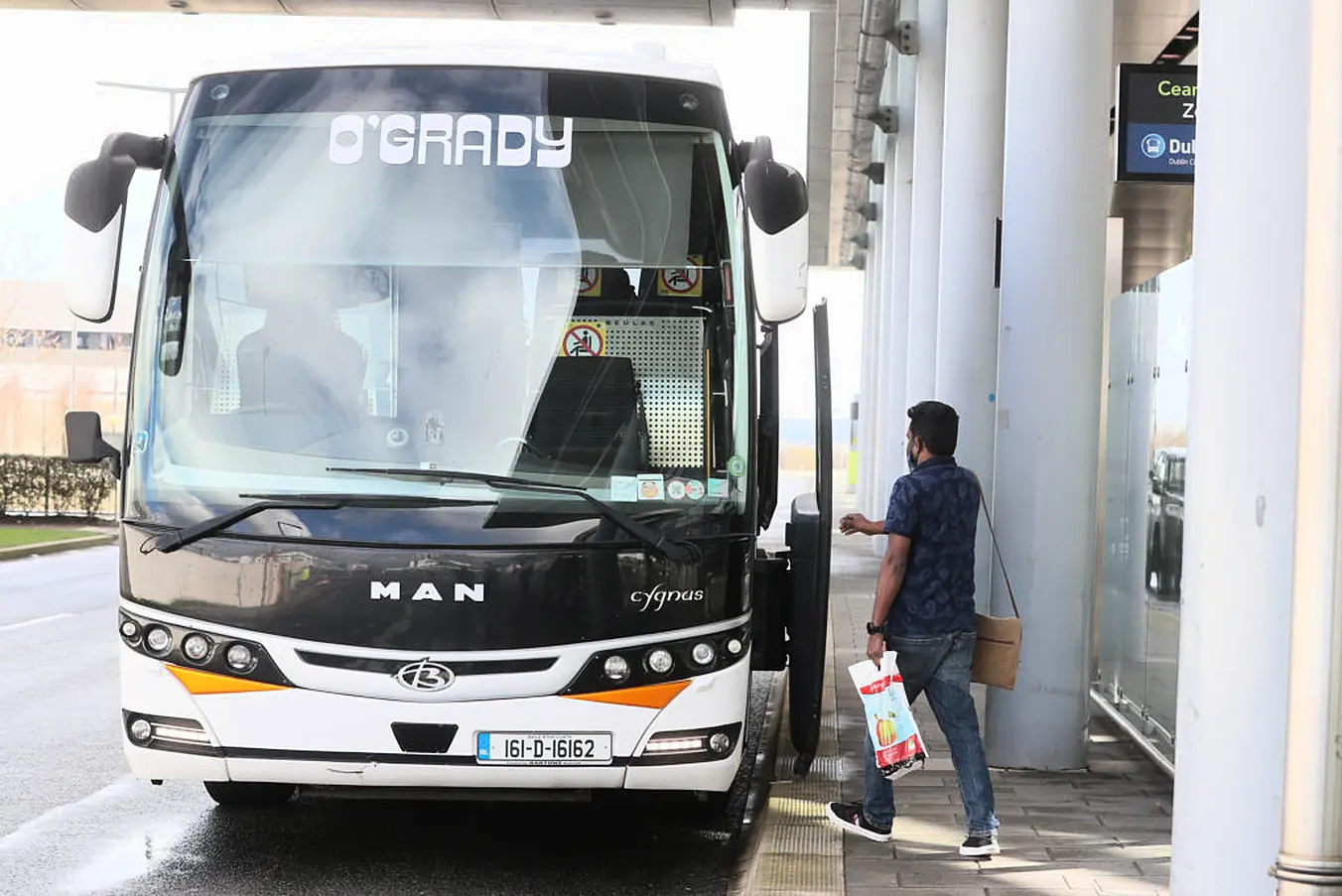 A Passenger Boards A Bus After Arriving From One Of 33 High Risk Countries. Photo: Pa Images.