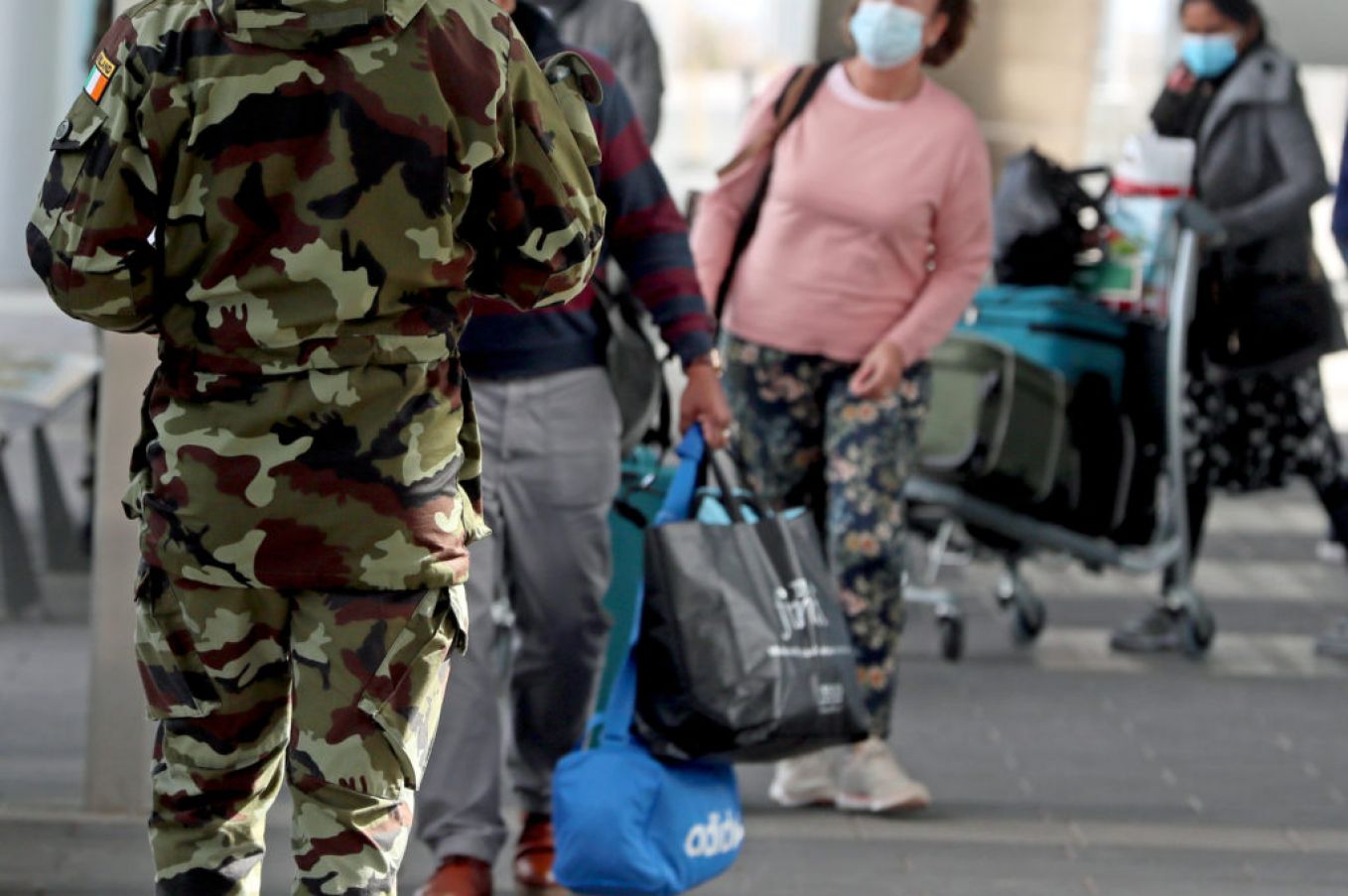 A Member Of The Defence Forces Directs Passengers Due To Undergo Hotel Quarantine At Dublin Airport. Photo: Pa Images