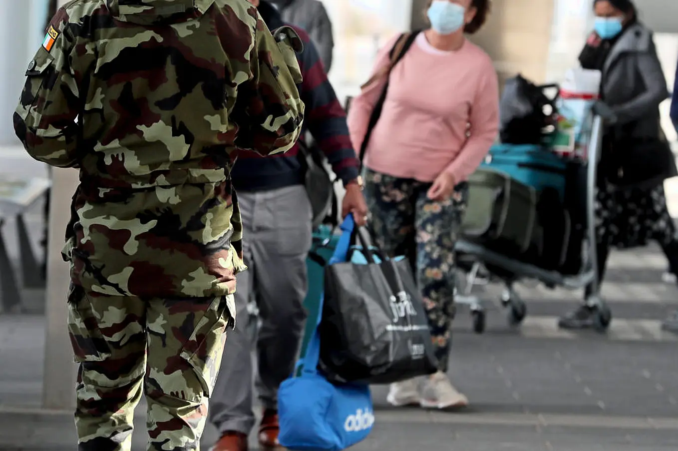 A Member Of The Defence Forces Directs Passengers Due To Undergo Hotel Quarantine At Dublin Airport. Photo: Pa Images