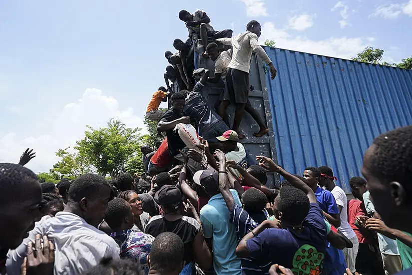 Haitian Quake Victims Rush Aid Sites To Take Food And Supplies